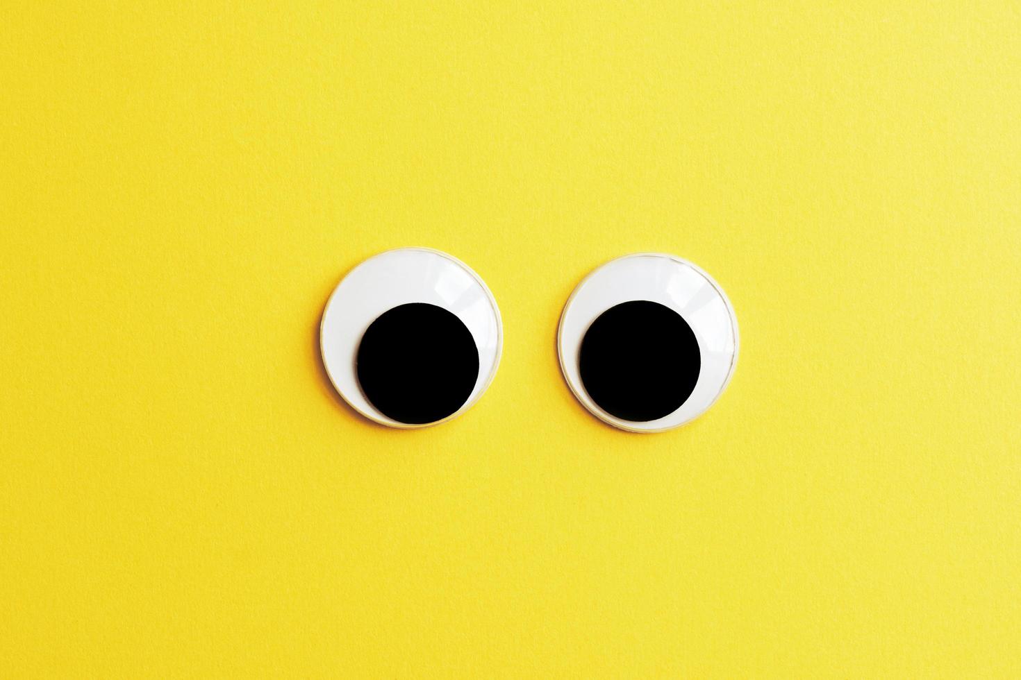 googly eyes on yellow color background photo