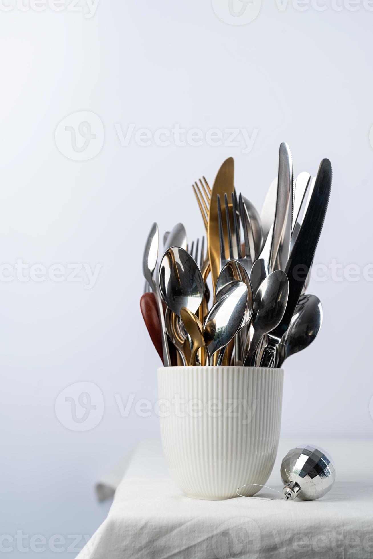 Set of cutlery of spoons, knives and forks in cup with holiday