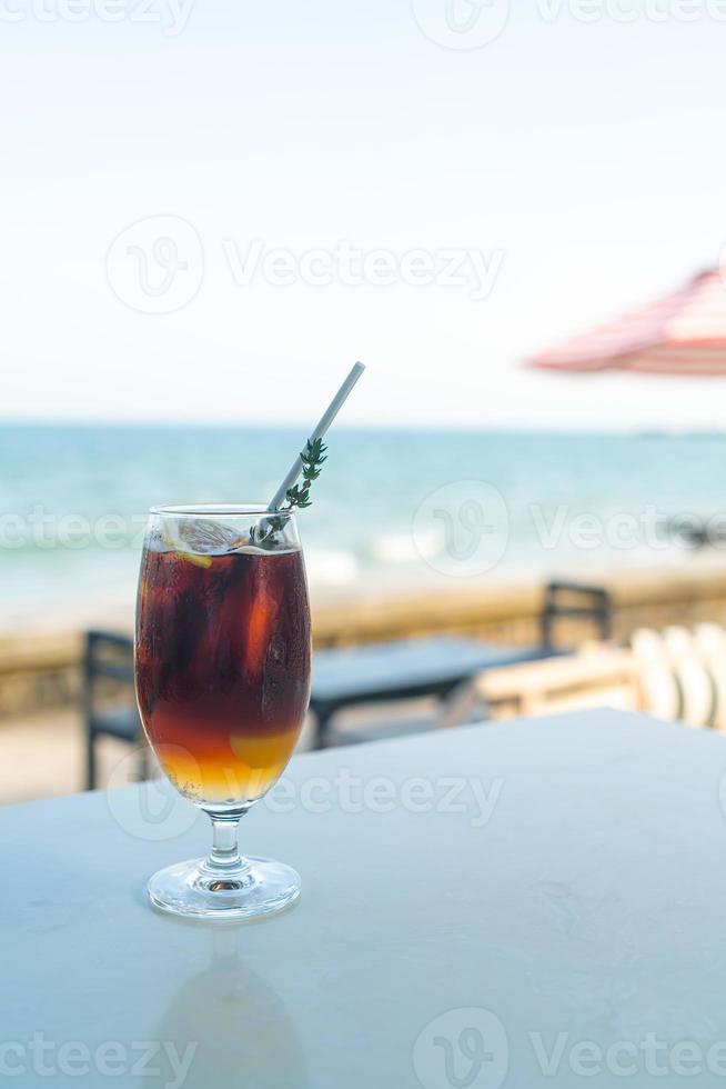 iced americano coffee peach with sea background photo