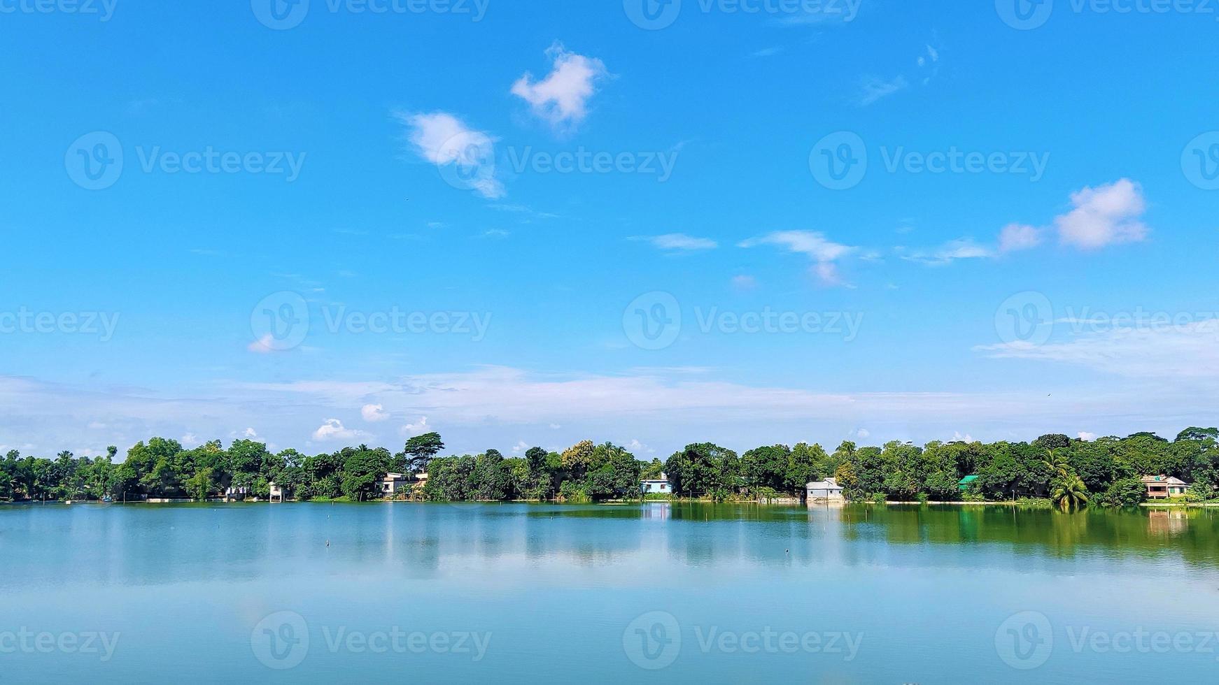 Beautiful shot of a lake surrounded by greenery under a cloudy sky photo
