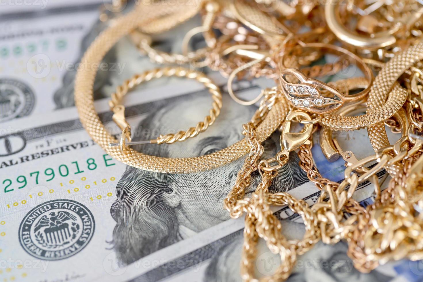 Many expensive golden jewerly rings, earrings and necklaces with big amount of US dollar bills on white background. Pawnshop or jewerly shop photo