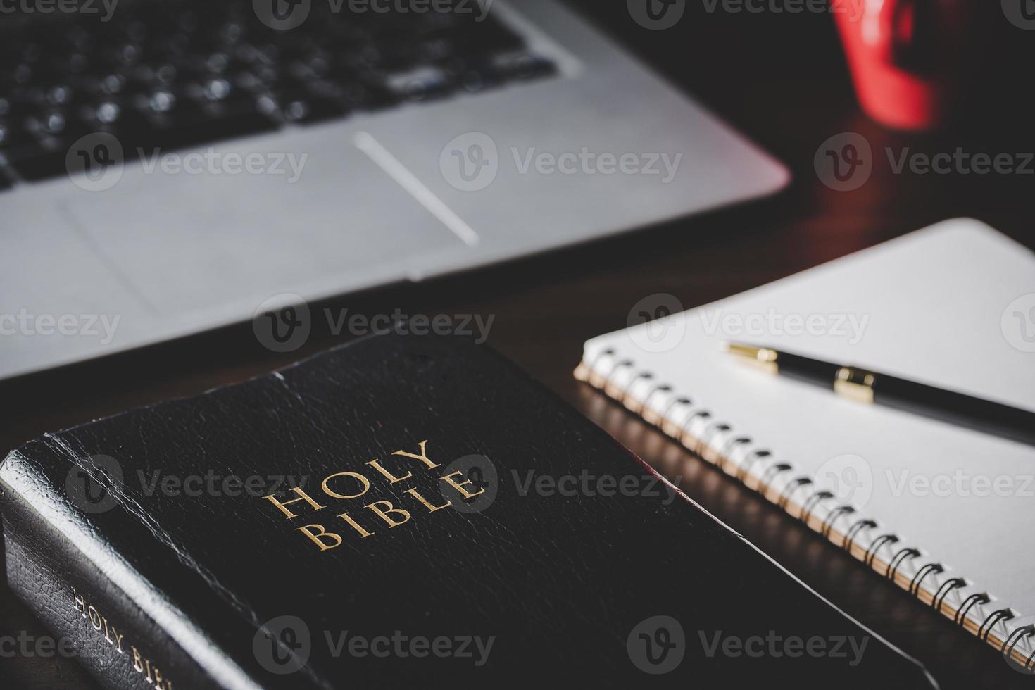 Holy bible book with paper for education on black wooden background. Christian catholic with protestant worship and pray in church. Concept of learning about faith god and religion, jesus spiritual. photo