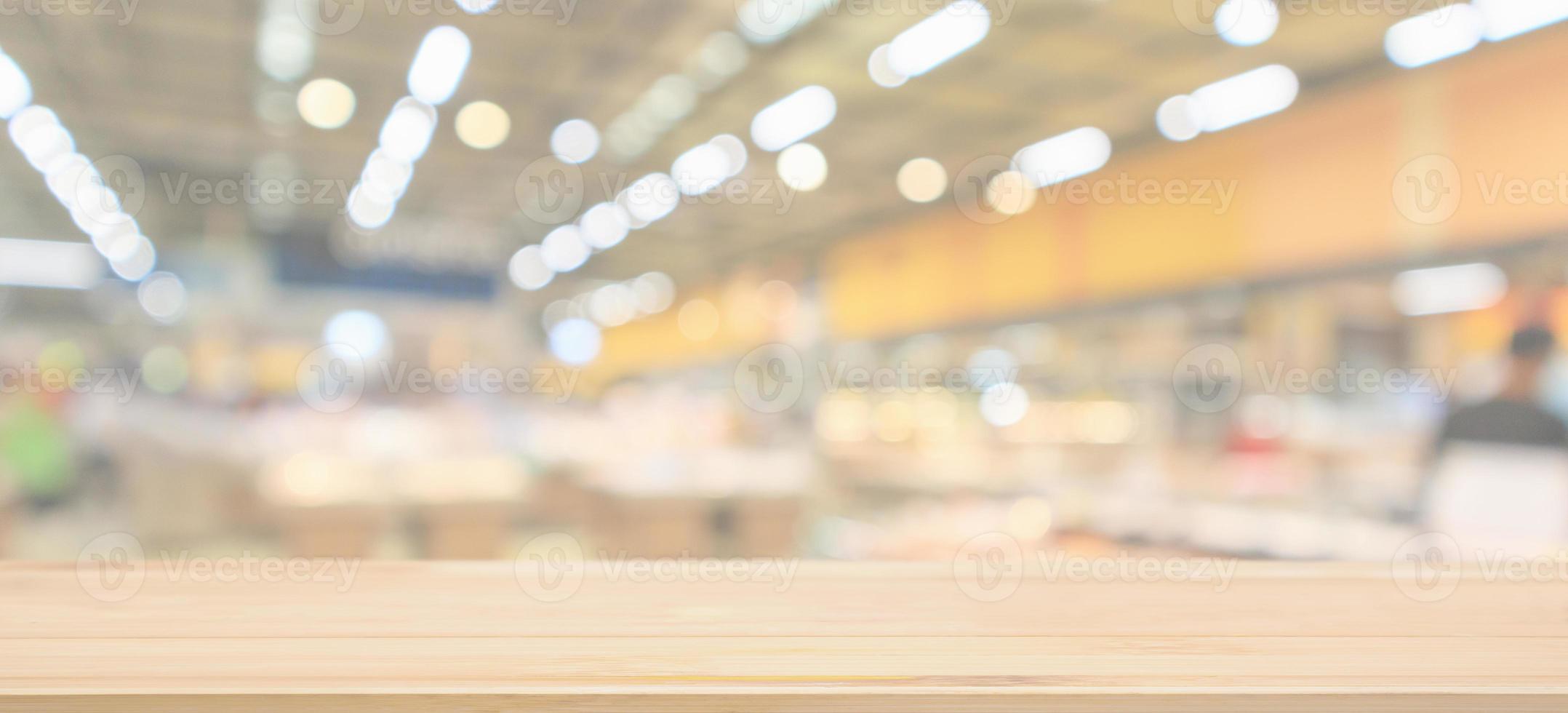 Empty wood table top with supermarket grocery store blurred defocused background with bokeh light for product display photo