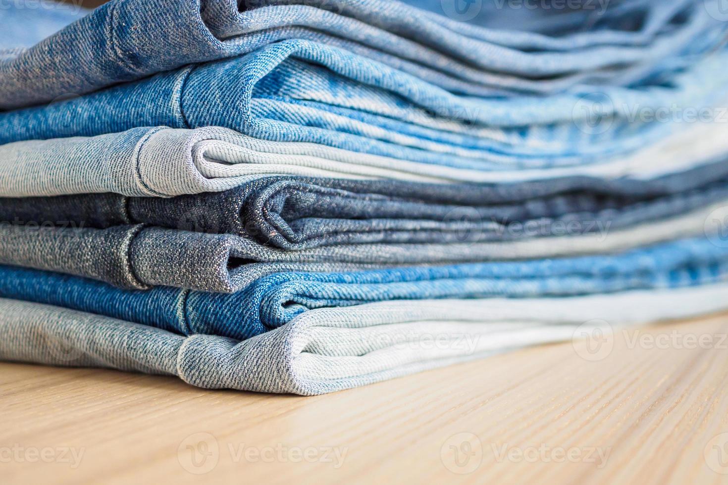 denim blue jeans stack on wood table background photo