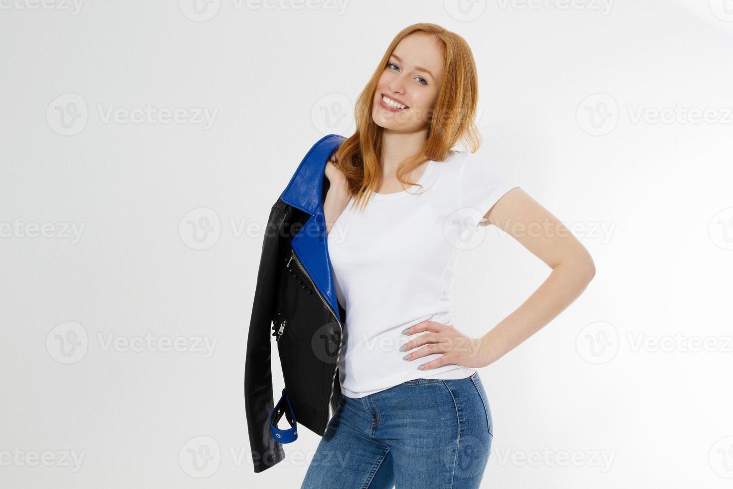 Woman in white t shirt and black leather jacket isolated on white background. Red hair girl in fashion clothes front view. Blank template summer t-shirt. Copy space photo