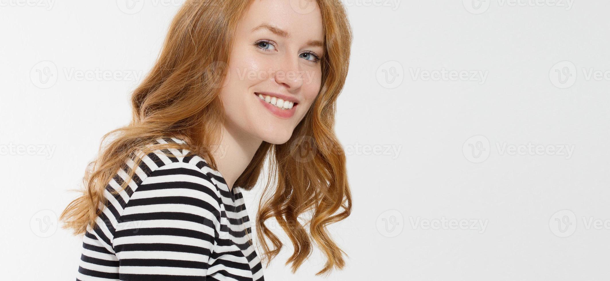 Red haired girl with close up macro face and perfect white teeth smile isolated on white background. Woman beauty and skin care. No make up concept. Redhead beautiful female. Selective focus. Banner photo