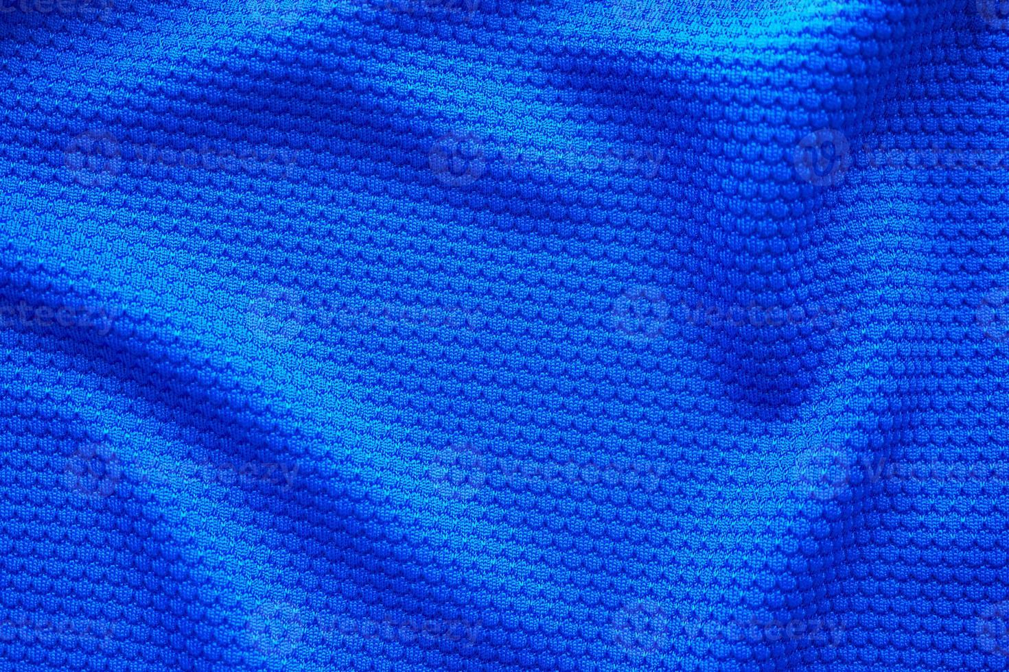 Blue football jersey clothing fabric texture sports wear background, close up top view photo