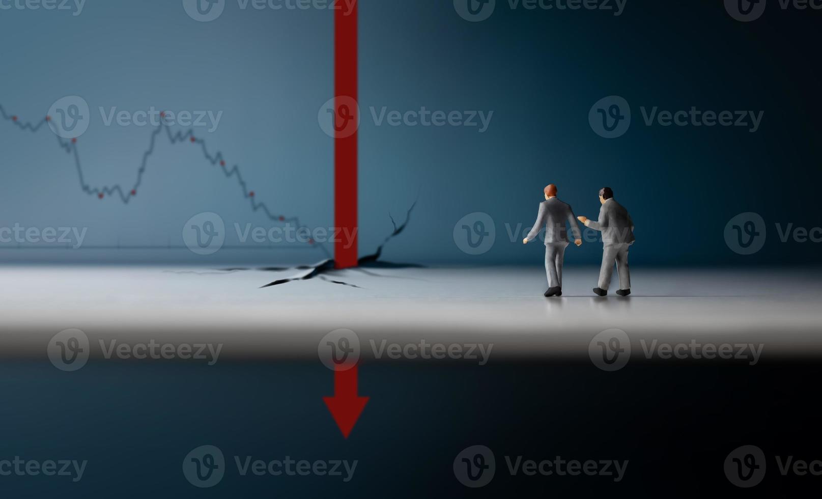 conceptos de recesión, inflación y depresión. crisis económica. el gráfico se cae, el negocio colapsa. dos figuras en miniatura de un hombre de negocios mirando una flecha gráfica roja cayendo profundamente foto