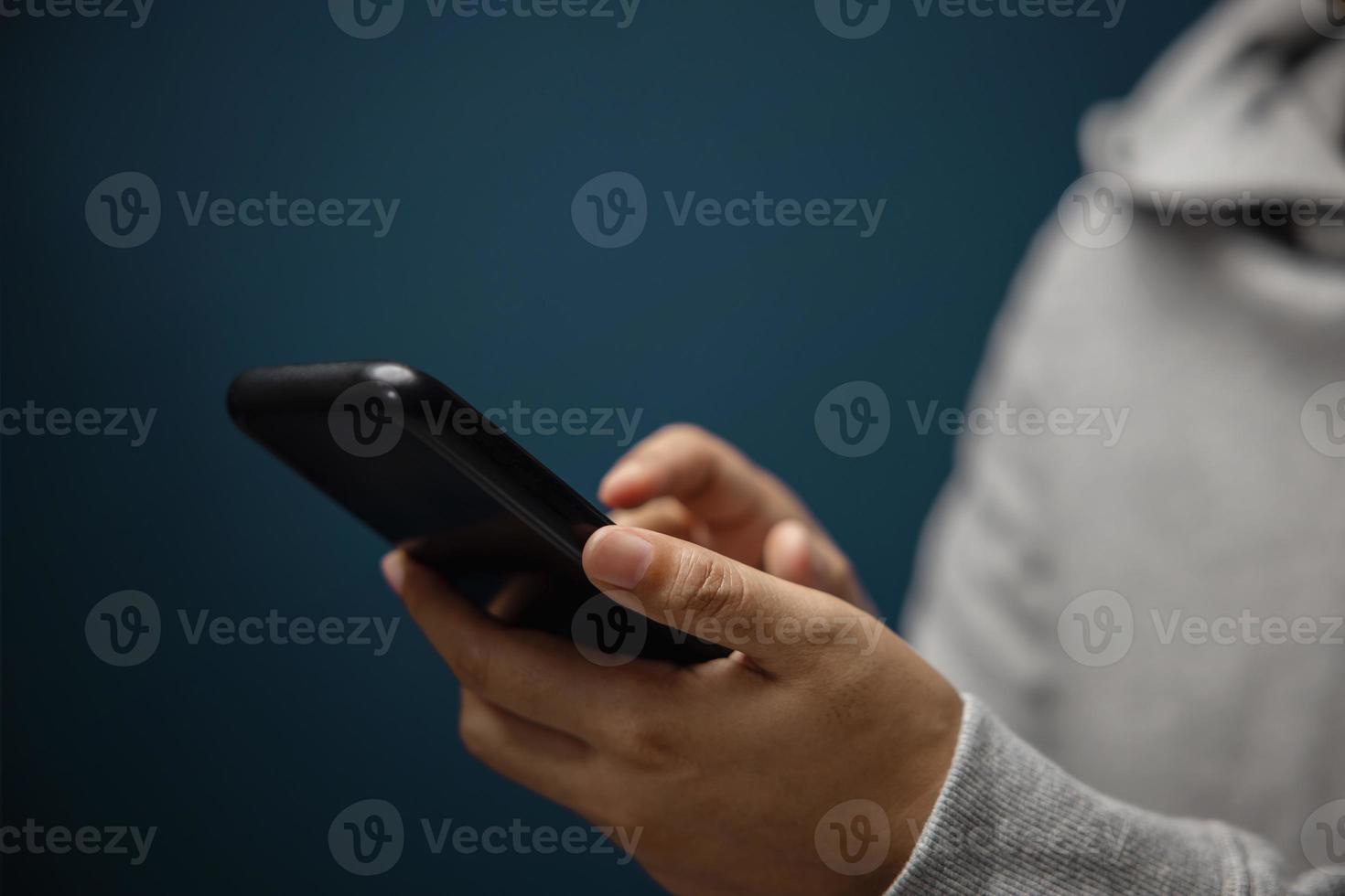 Closeup of Hand Using Mobile Phone. Cropped image. Selective Focus. Using Smartphone for Communication, Texting, Reading or Playing Game photo