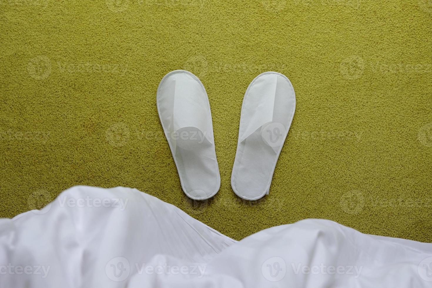 Hotel Services Concept. White Slipper Lay on the Carpet in Bedroom. Top View photo