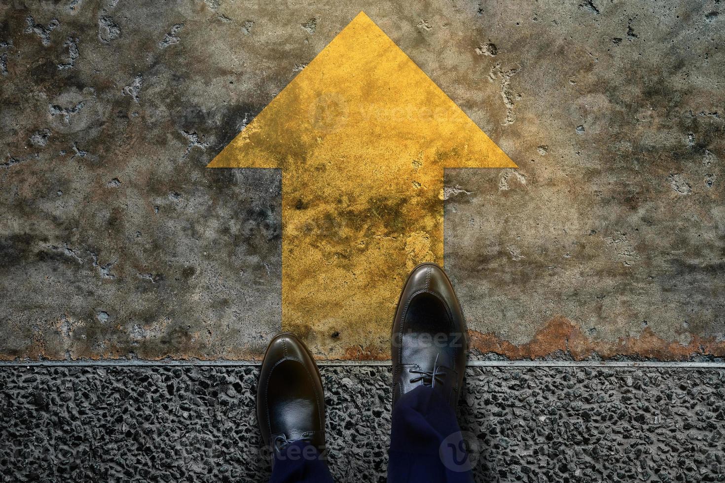 Start and Challenge Concept. a Business Man on Formal Shoes Steps to Follow a Yellow Arrow, Get Ready to Moving Forward or take a Chance to Success. Top View photo