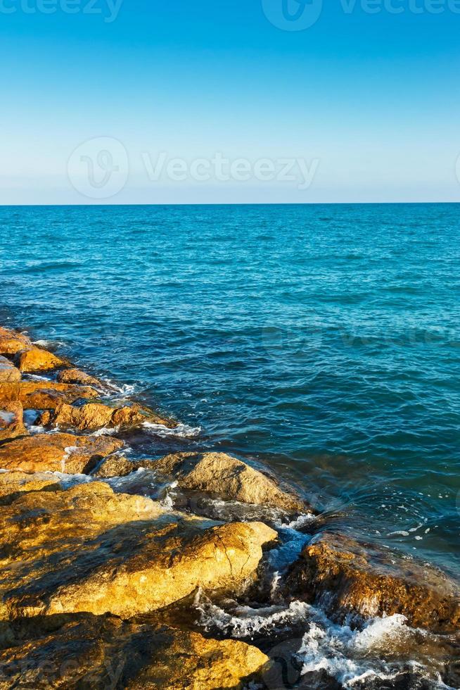 piedras del rompeolas del mar. imagen vertical foto