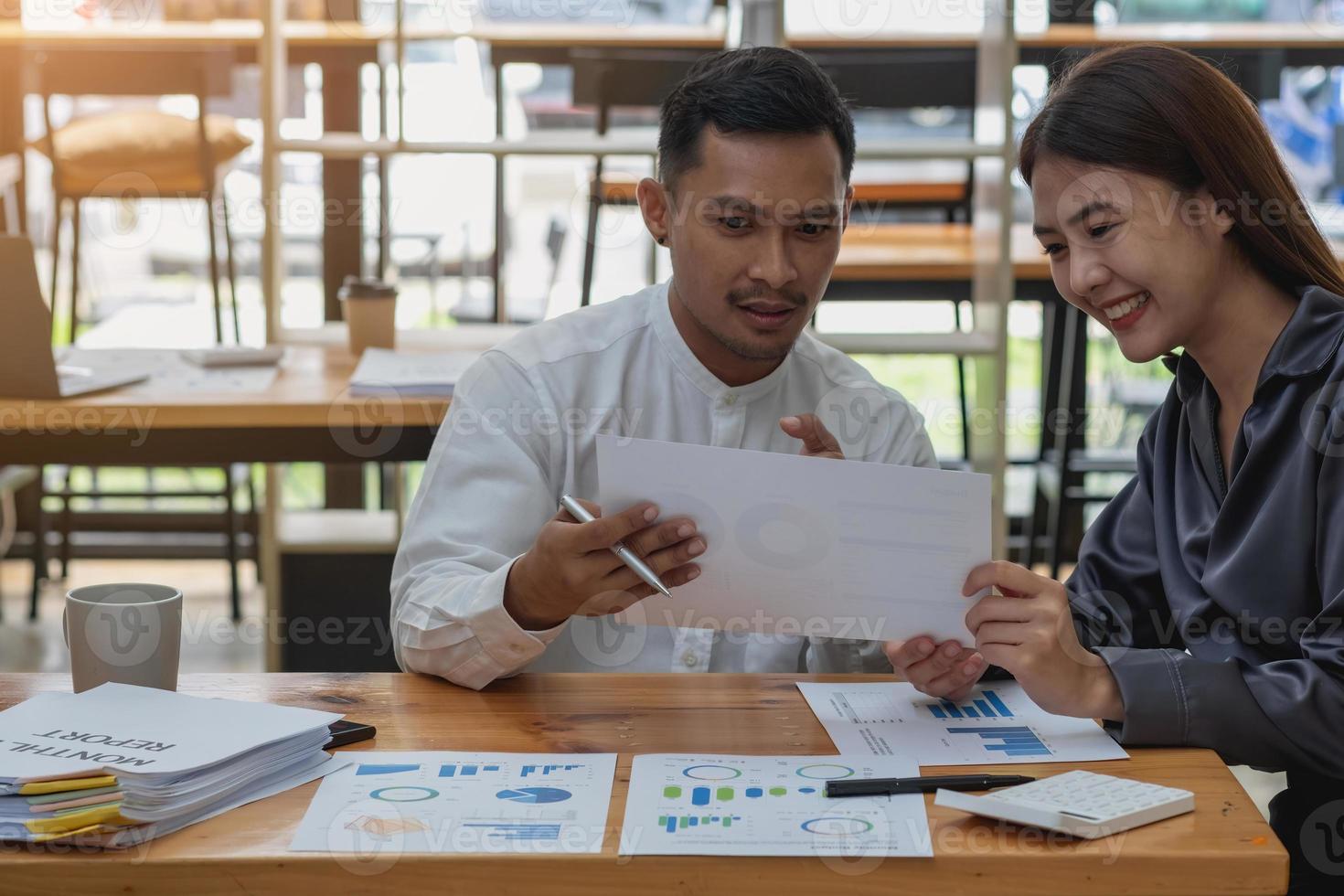 el equipo de especialistas en marketing de la empresa analiza las ganancias de la empresa mediante gráficos y calculadoras de computadoras portátiles. foto