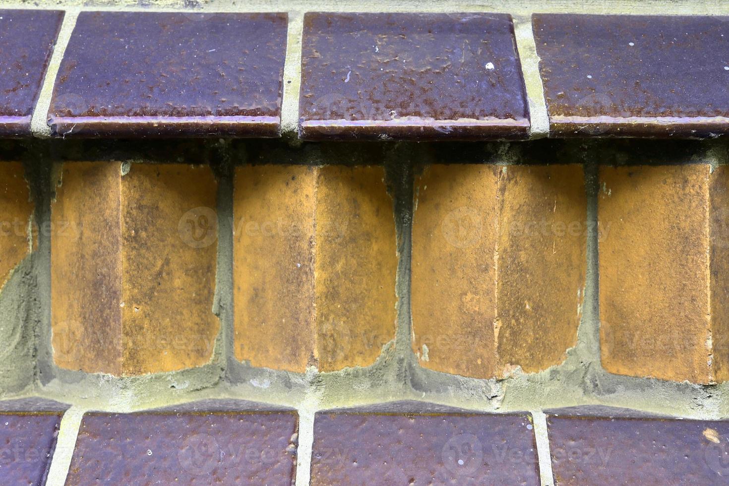 Detailed view at a colorful old and weathered brick wall texture as a panoramic background. photo