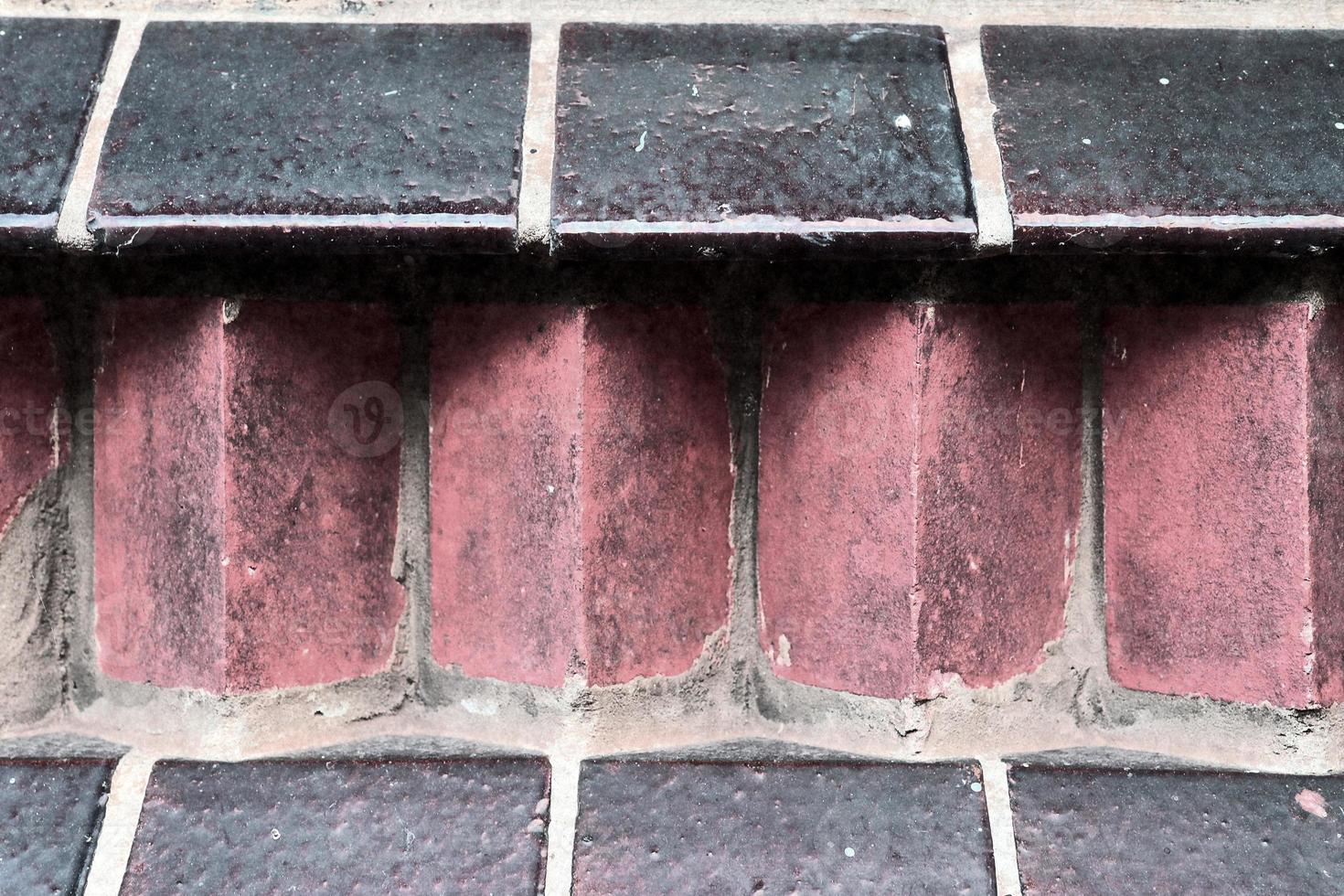 Detailed view at a colorful old and weathered brick wall texture as a panoramic background. photo