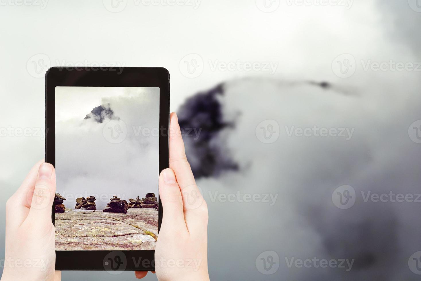 tourist taking photo of stone pyramid in mountain