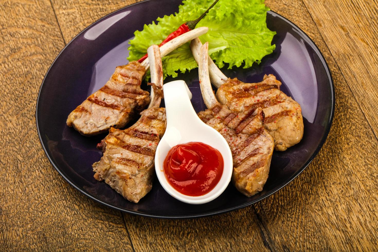 Grilled lamb on the plate and wooden background photo