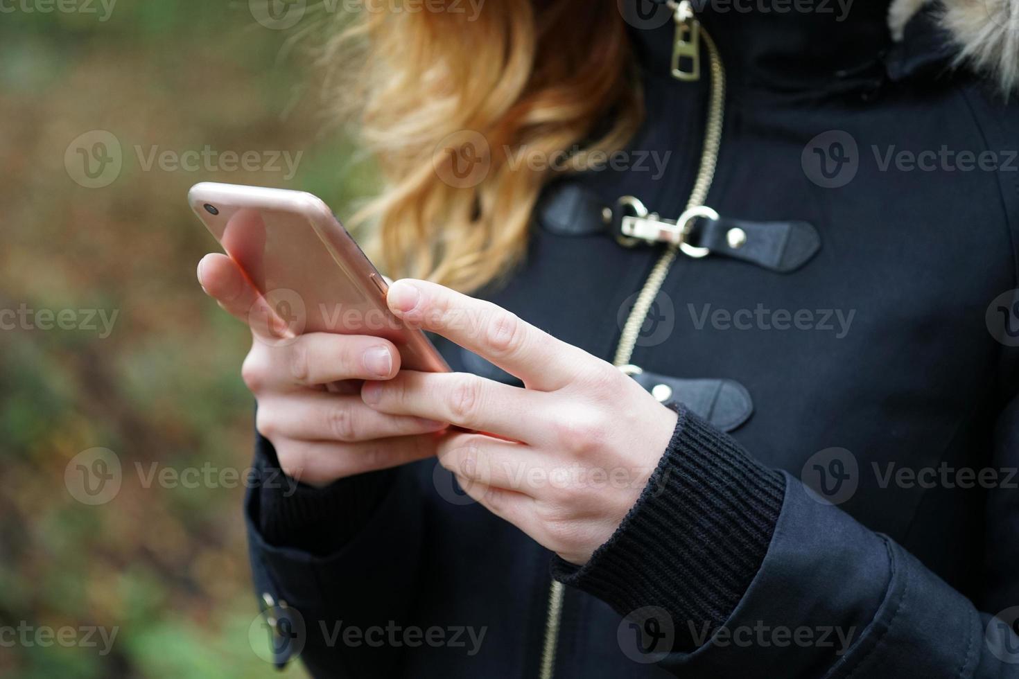 unrecogniazble woman using her smartphone photo