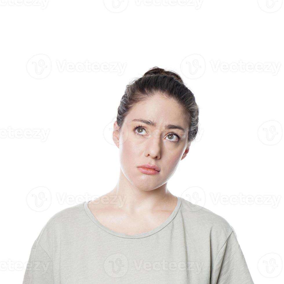 worried thoughtful young woman with concerned look on her face looking up contemplating idea or problem photo