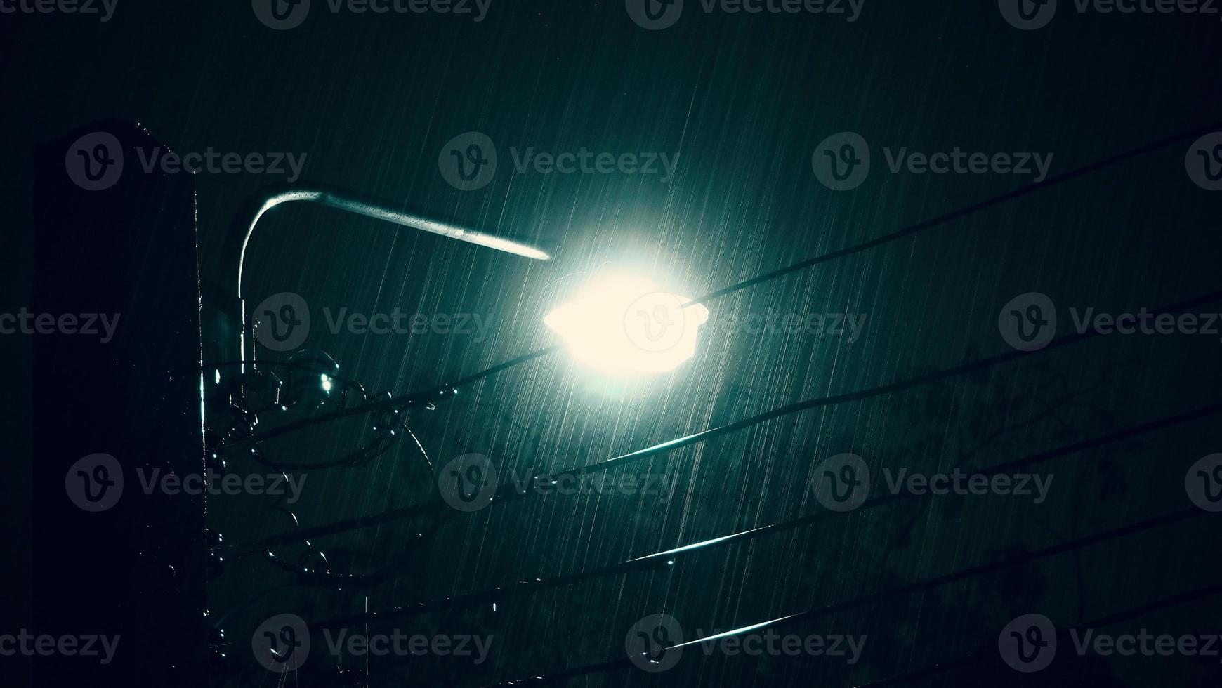Raining Night and light. Rain Drops Falling in night at Bangkok Thailand in August raining season. photo