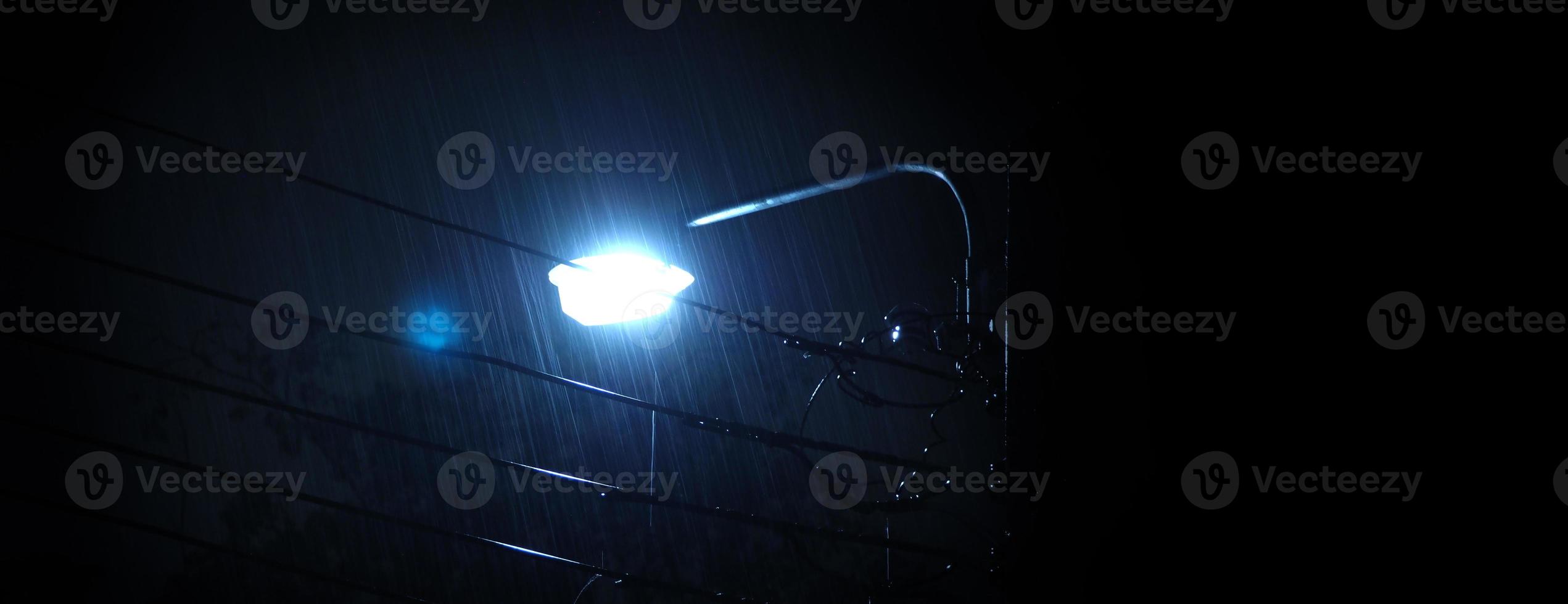 lloviendo noche y luz. gotas de lluvia cayendo en la noche en bangkok, tailandia, en la temporada de lluvias de agosto. foto