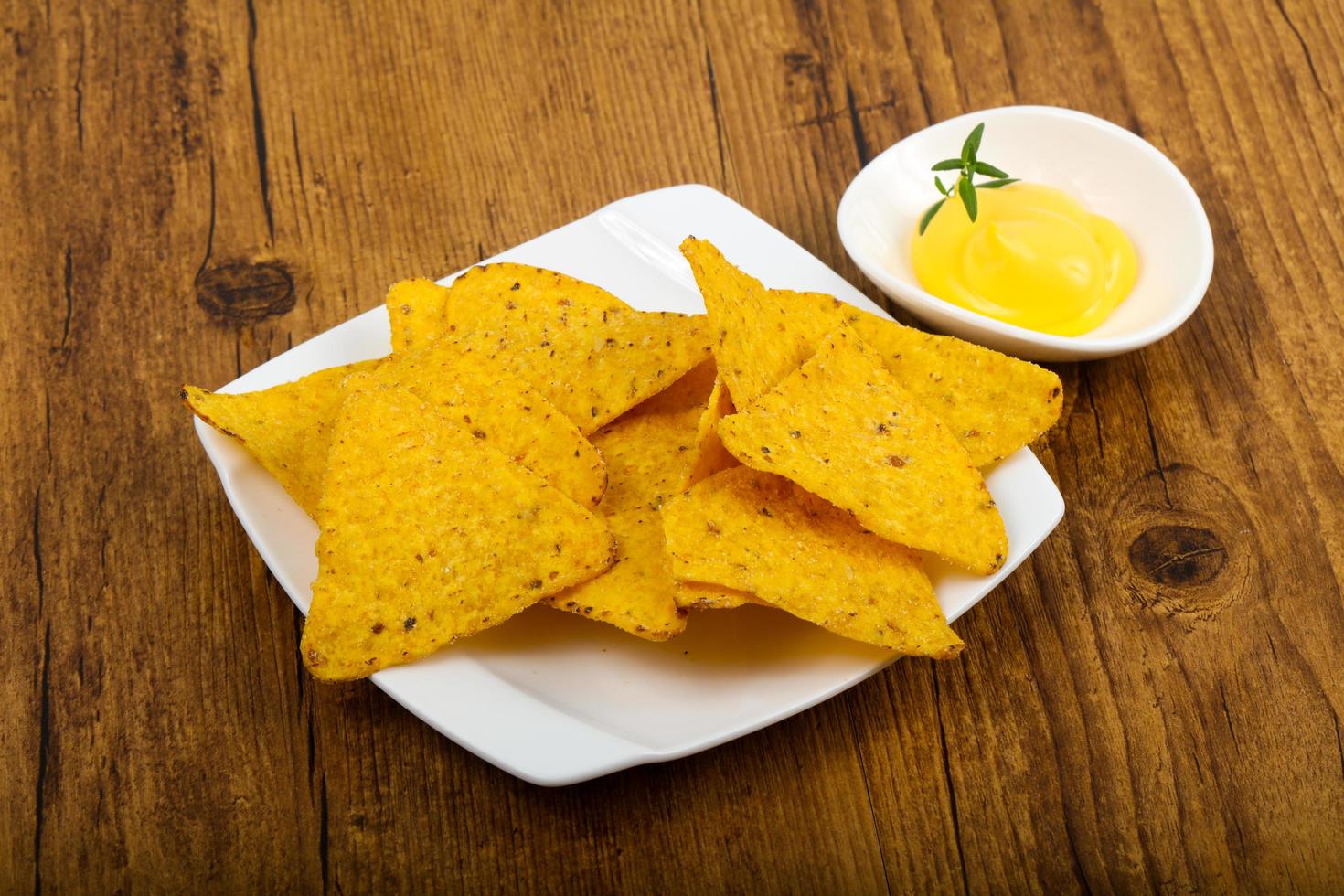 Nachos on the plate and wooden background photo