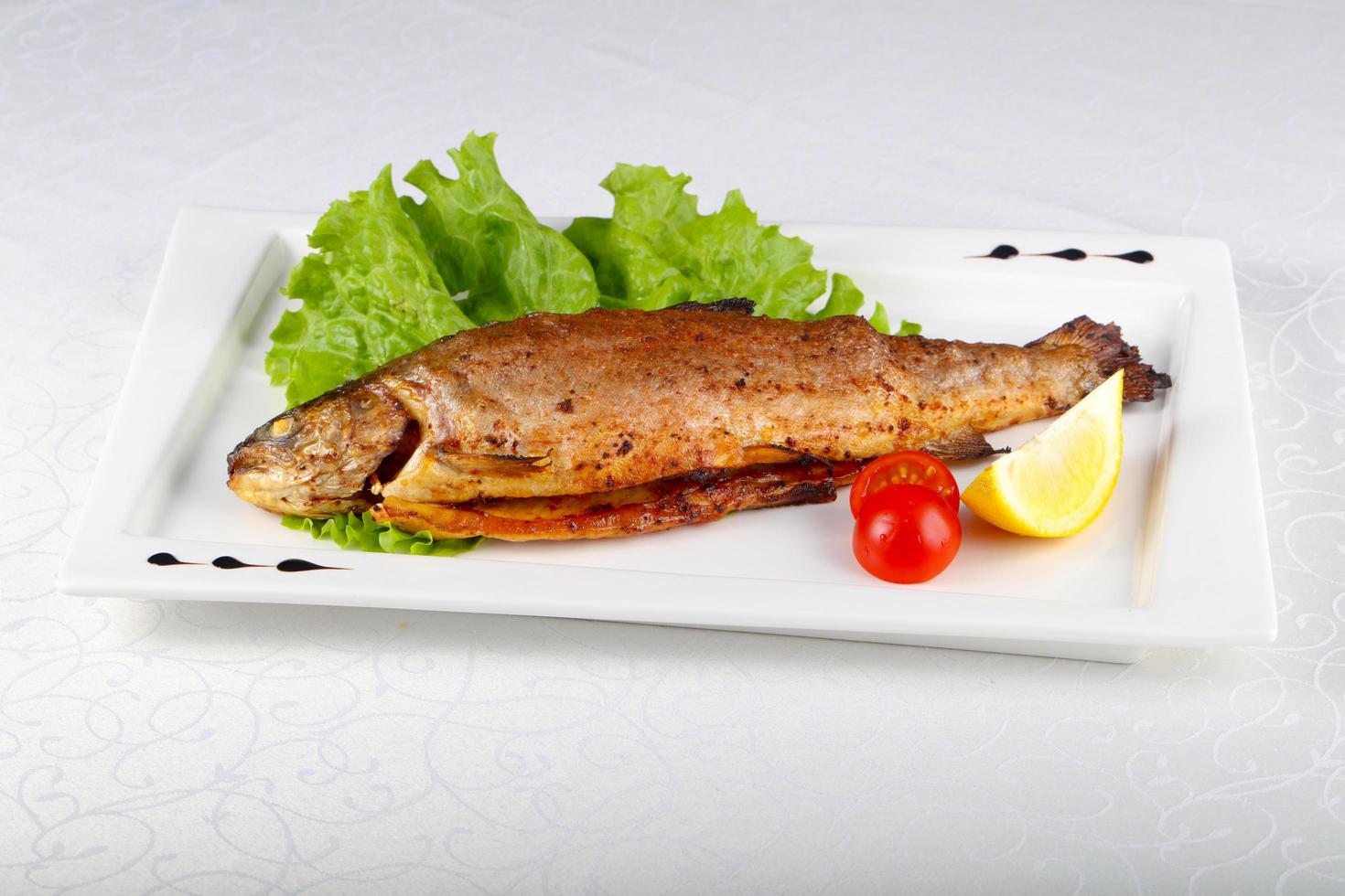 Grilled trout on the plate and white background photo