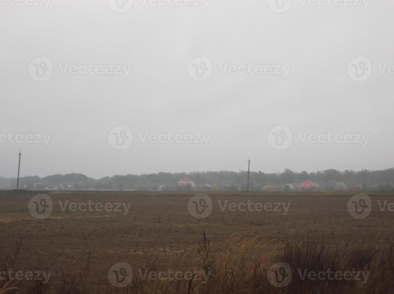 Panorama of a plowed field in the village at sunset photo