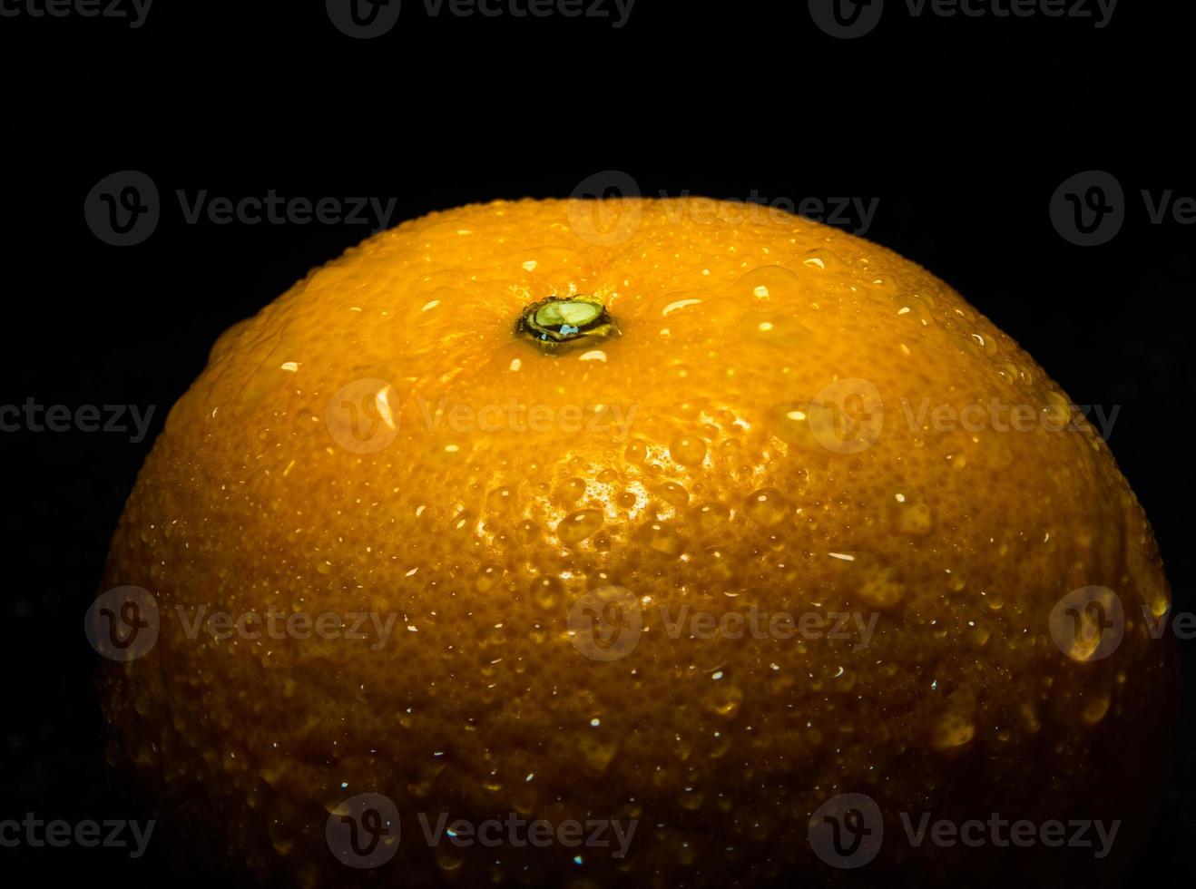 Water droplet on glossy surface of freshness orange on black background photo