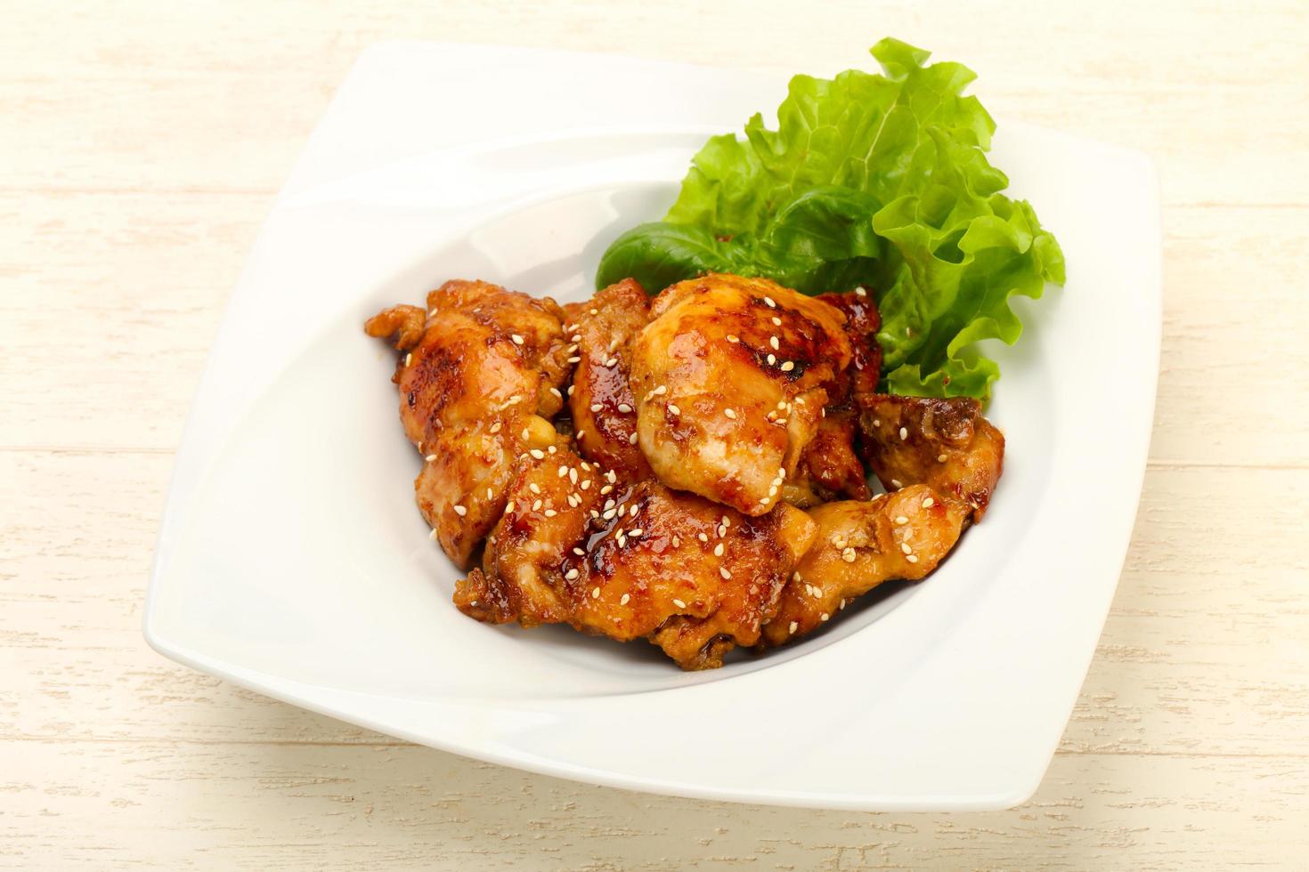 Teriyaki thighs on the plate and wooden background photo