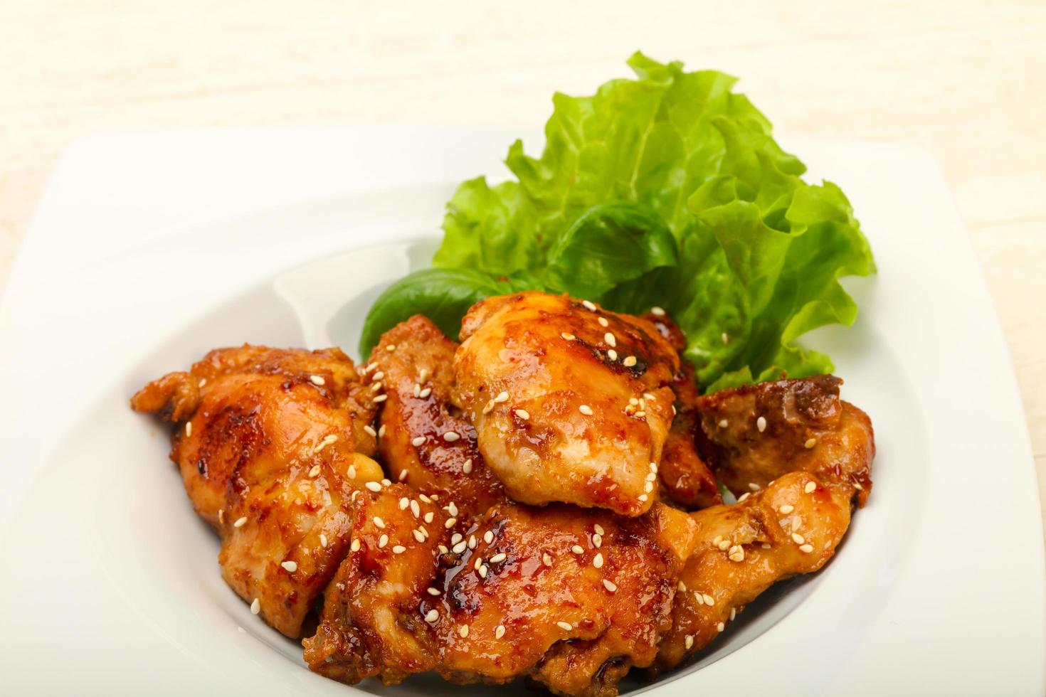 Teriyaki thighs on the plate and wooden background photo