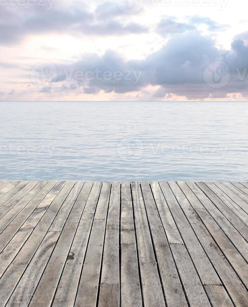 wooden floor and blue sea with waves and cloudy sky photo