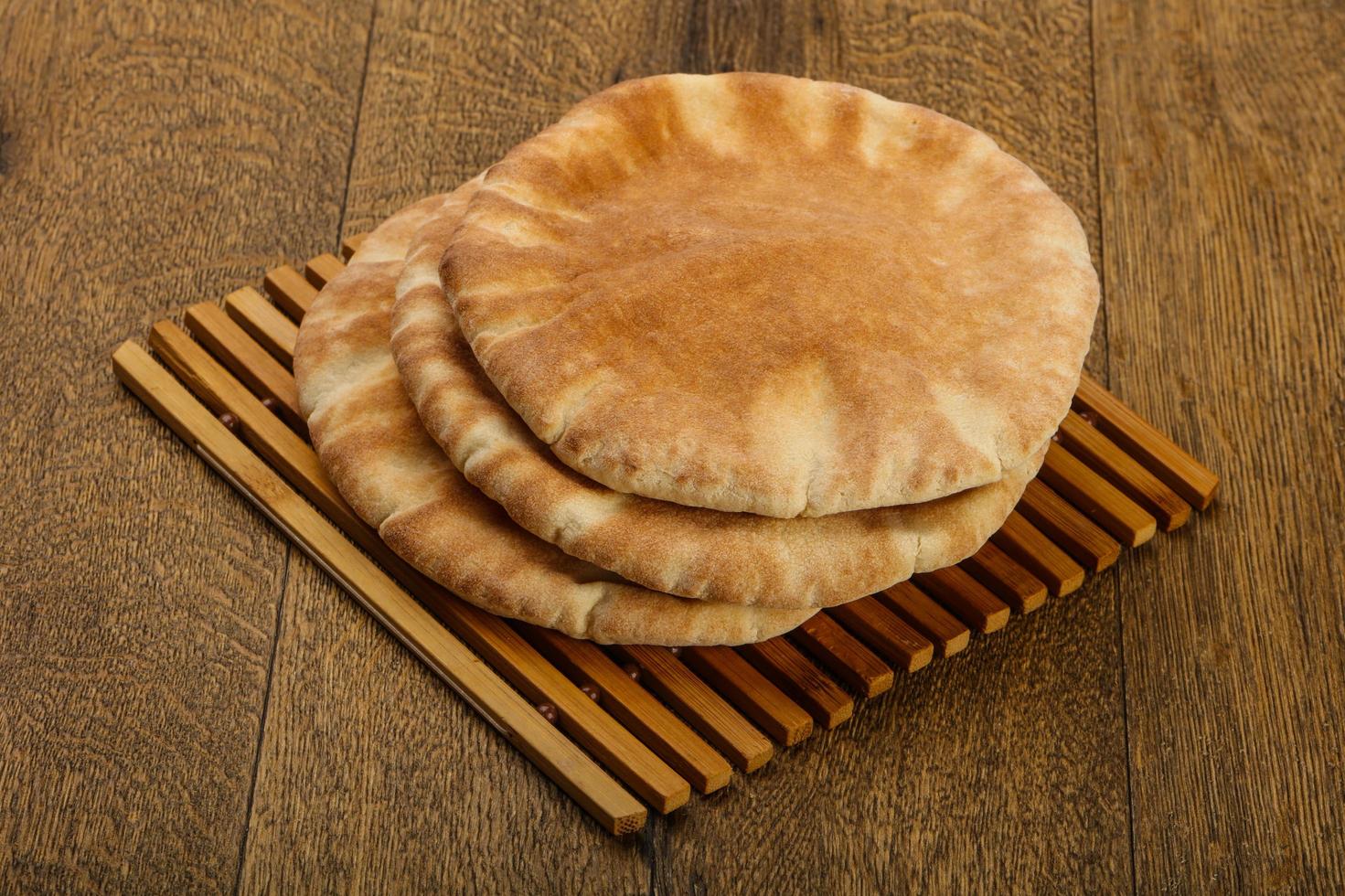 Pita bread on wooden board and wooden background photo