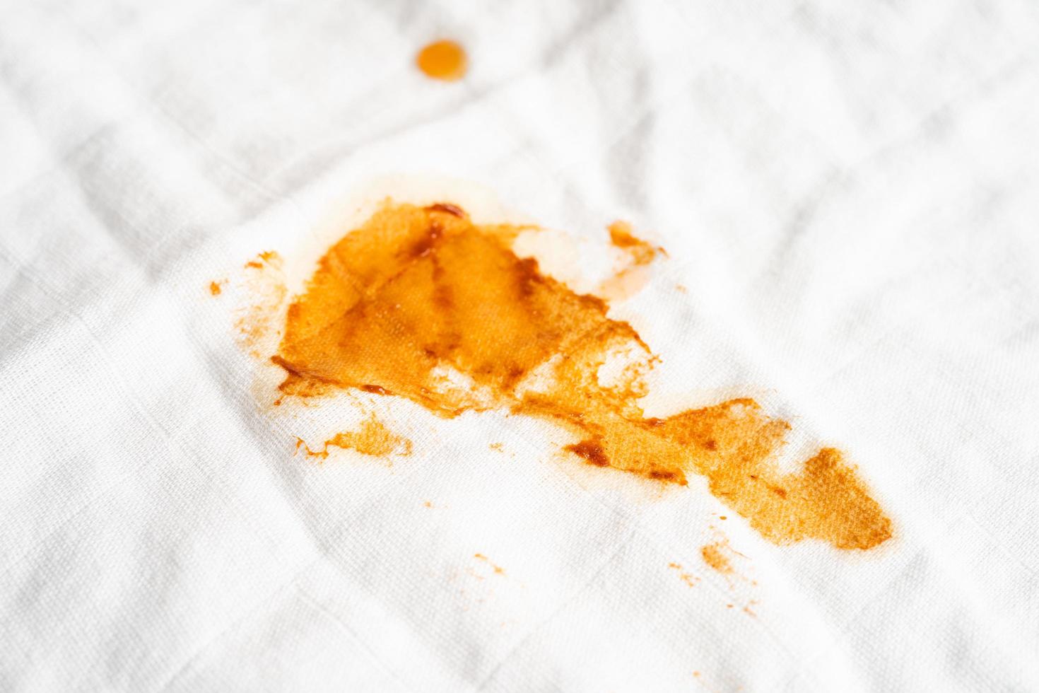 Dirty spicy sauce stain on cloth to wash with washing powder, cleaning housework concept. photo