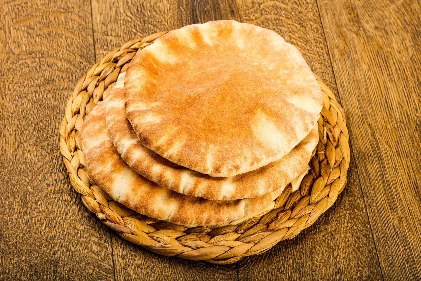 Pita bread on wooden board and wooden background photo