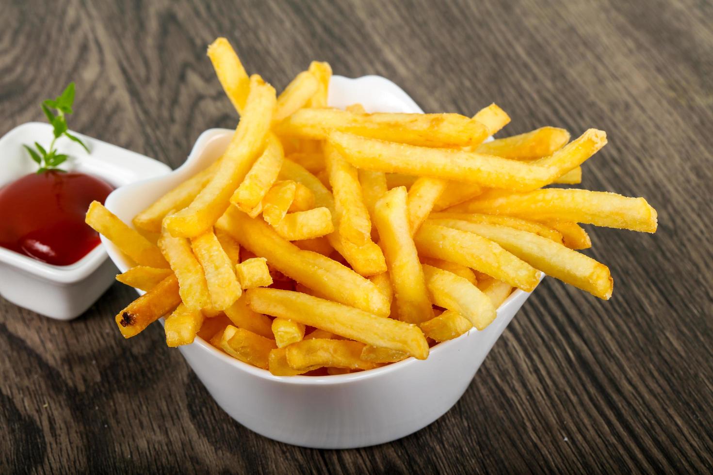 French fries in a bowl on wooden background photo