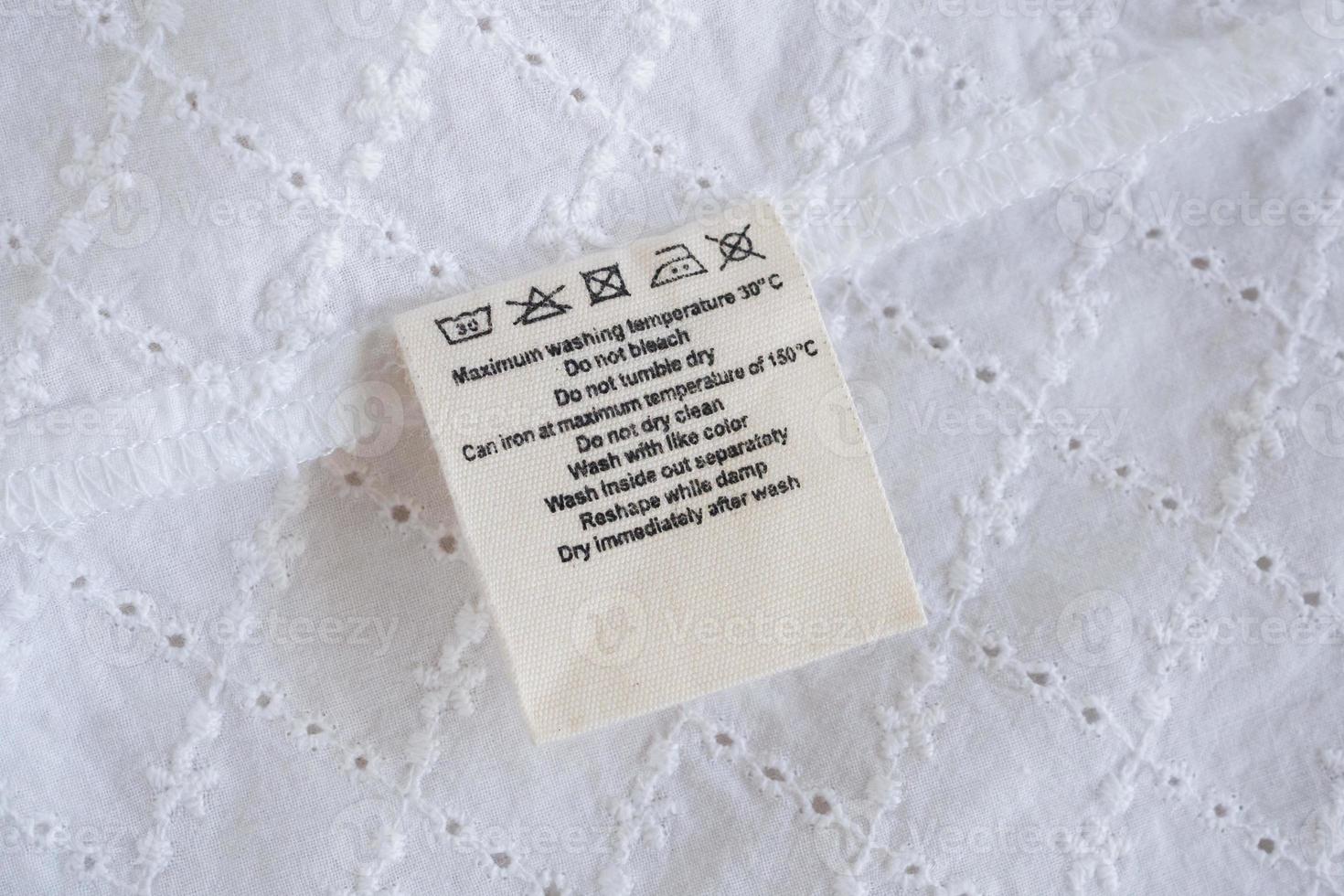 laundry care washing instructions clothes label on fabric texture background photo