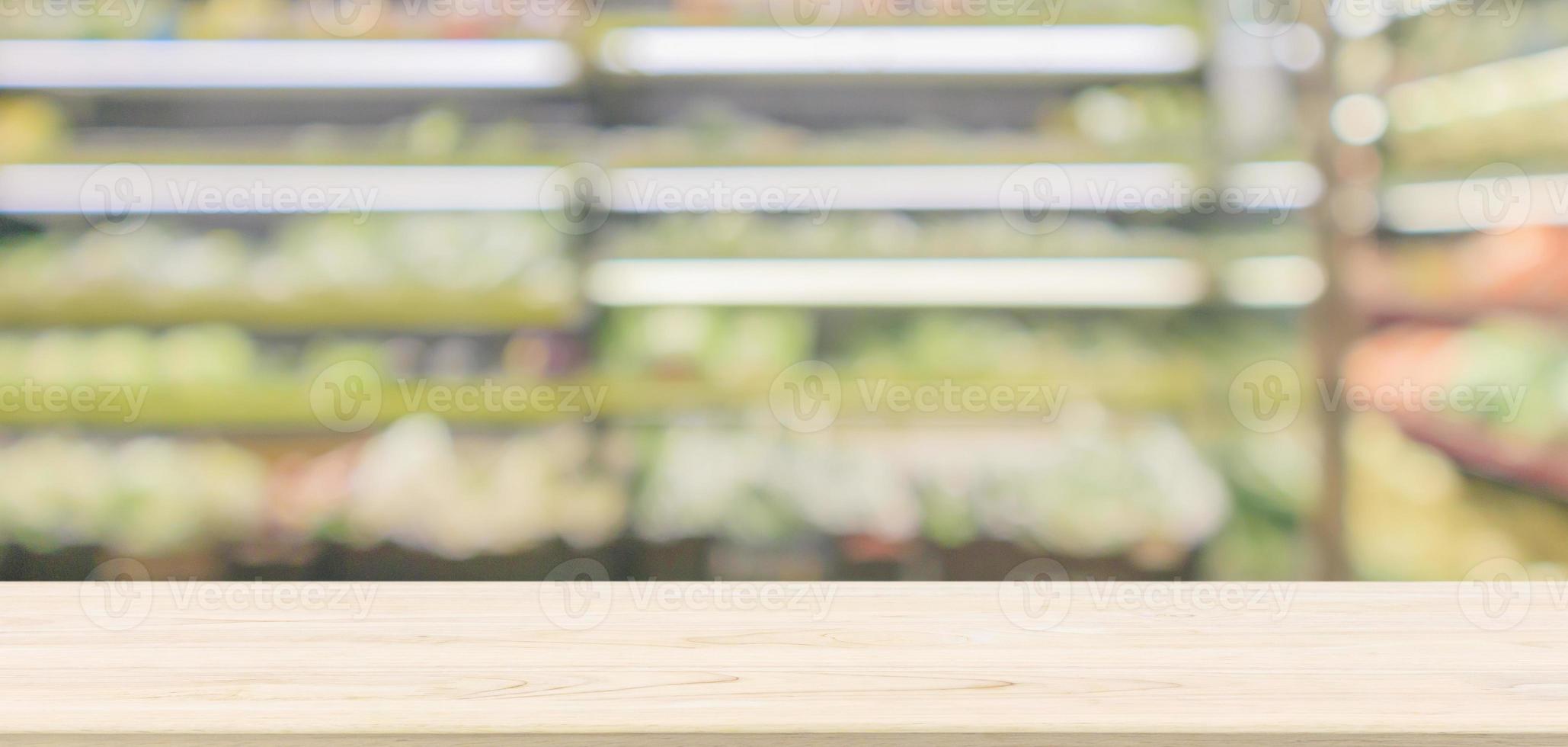 Empty wood table top with abstract blur organic fresh fruits and vegetable on grocery shelves in supermarket store defocused bokeh light background photo