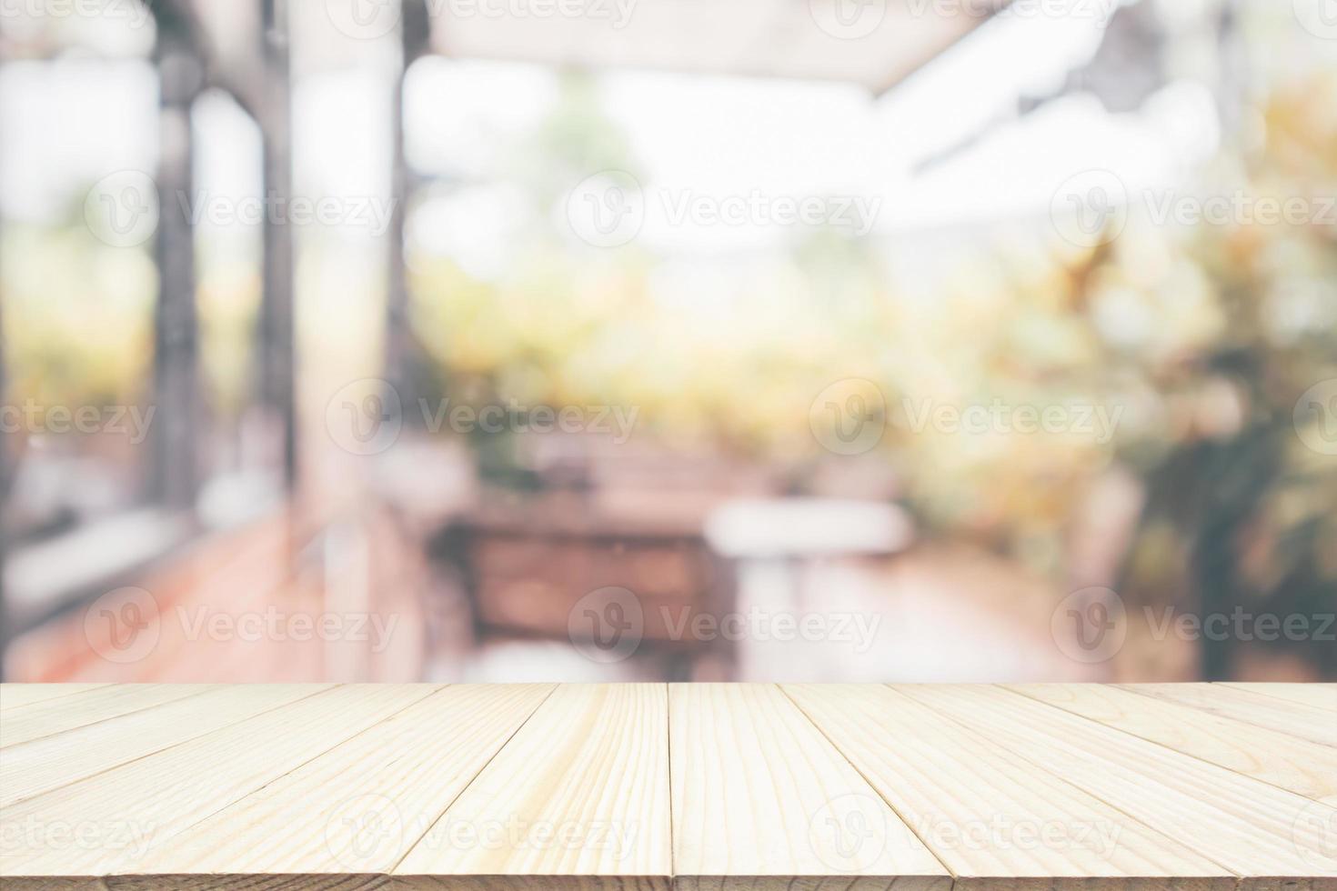 Empty wooden table top with cafe restaurant coffee shop interior abstract blur defocused with bokeh light background for montage product display photo