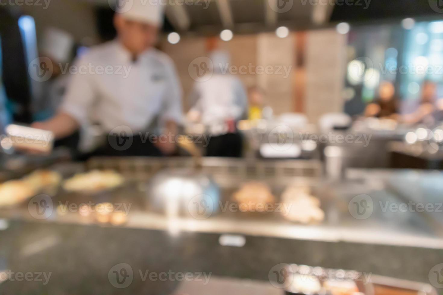 Chef cooking in restaurant kitchen blurred defocused background photo