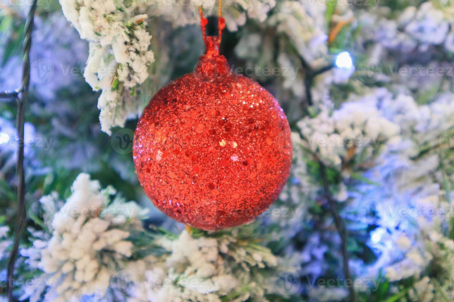 Christmas tree decorated with red ball on pine branches background photo