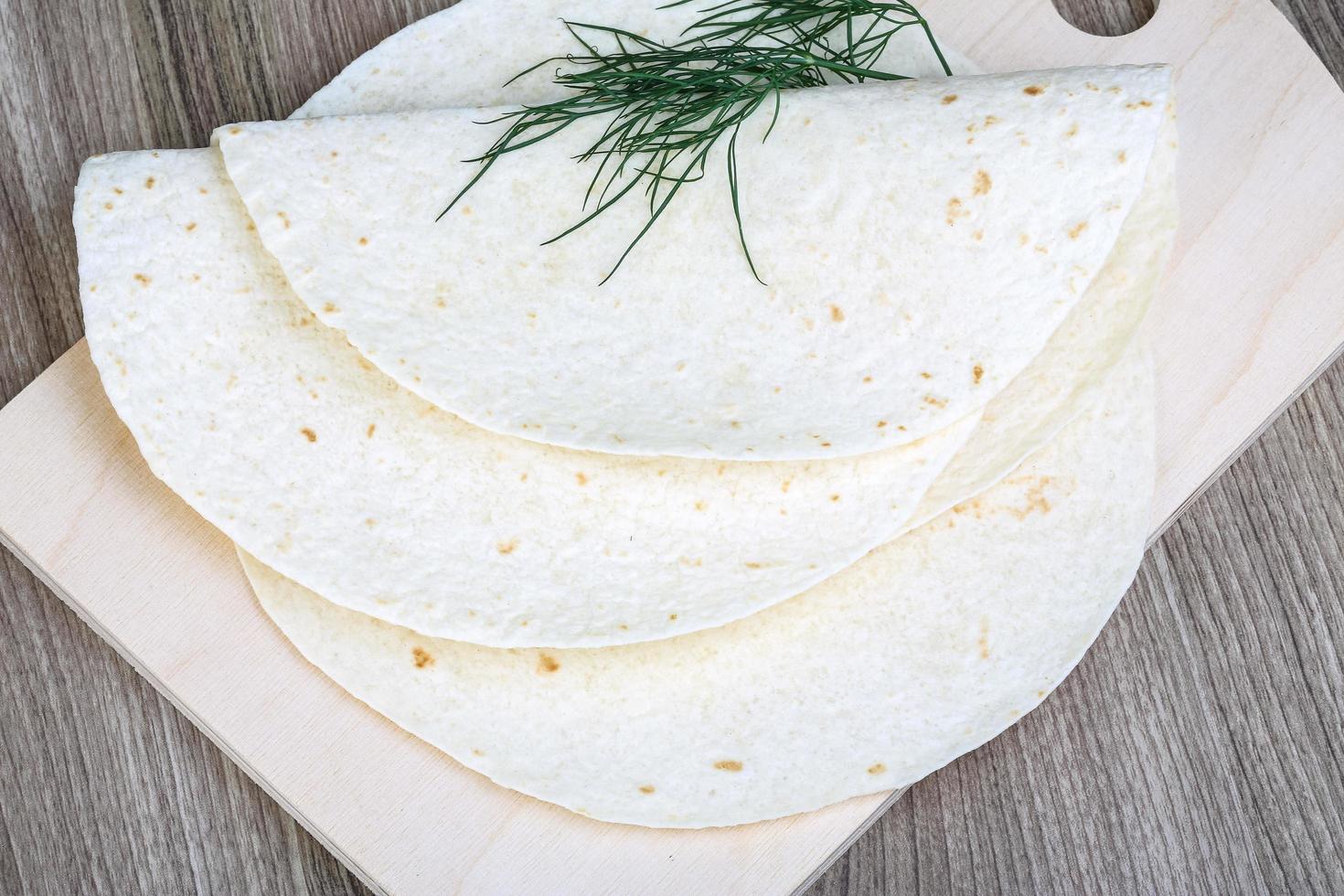 tortillas en tablero de madera y fondo de madera foto