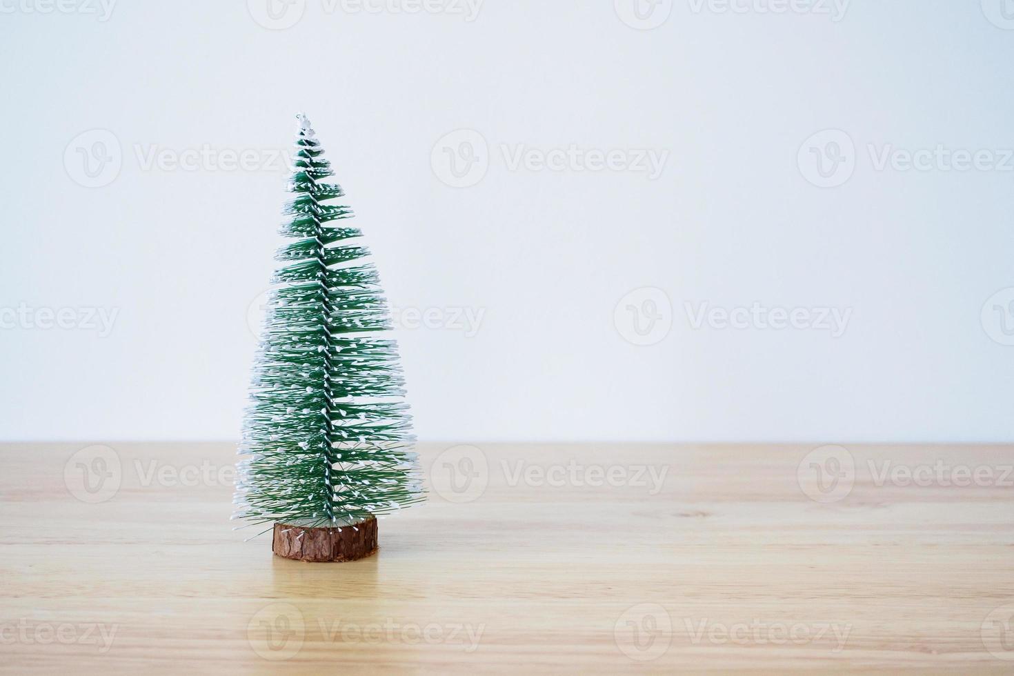 christmas tree on wood table with white wall background photo