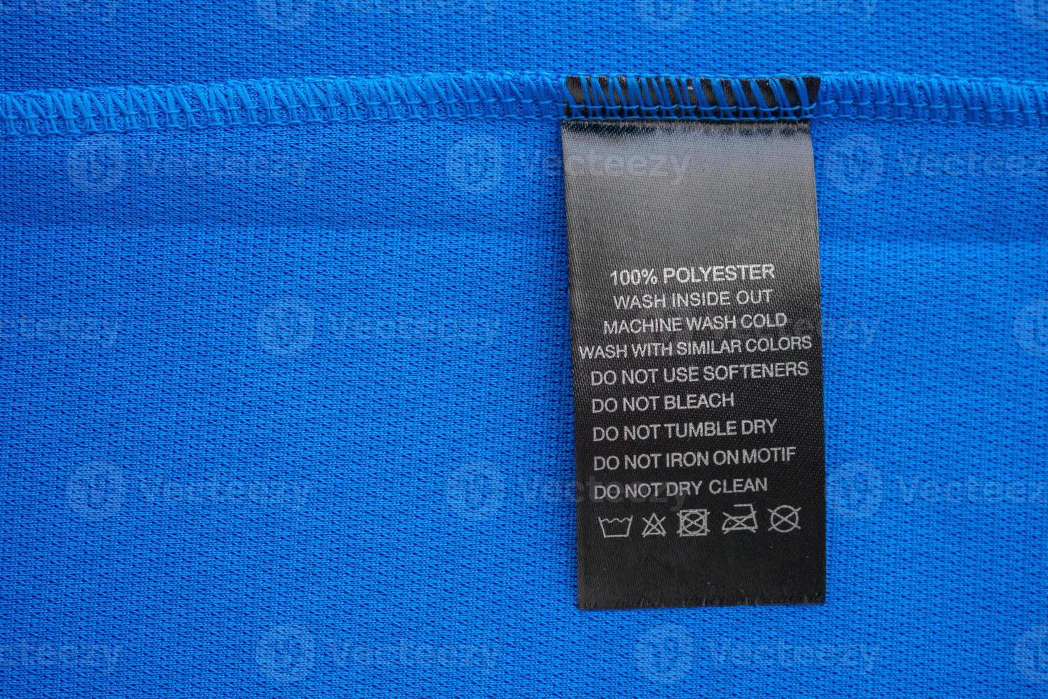 Black laundry care washing instructions clothes label on blue jersey