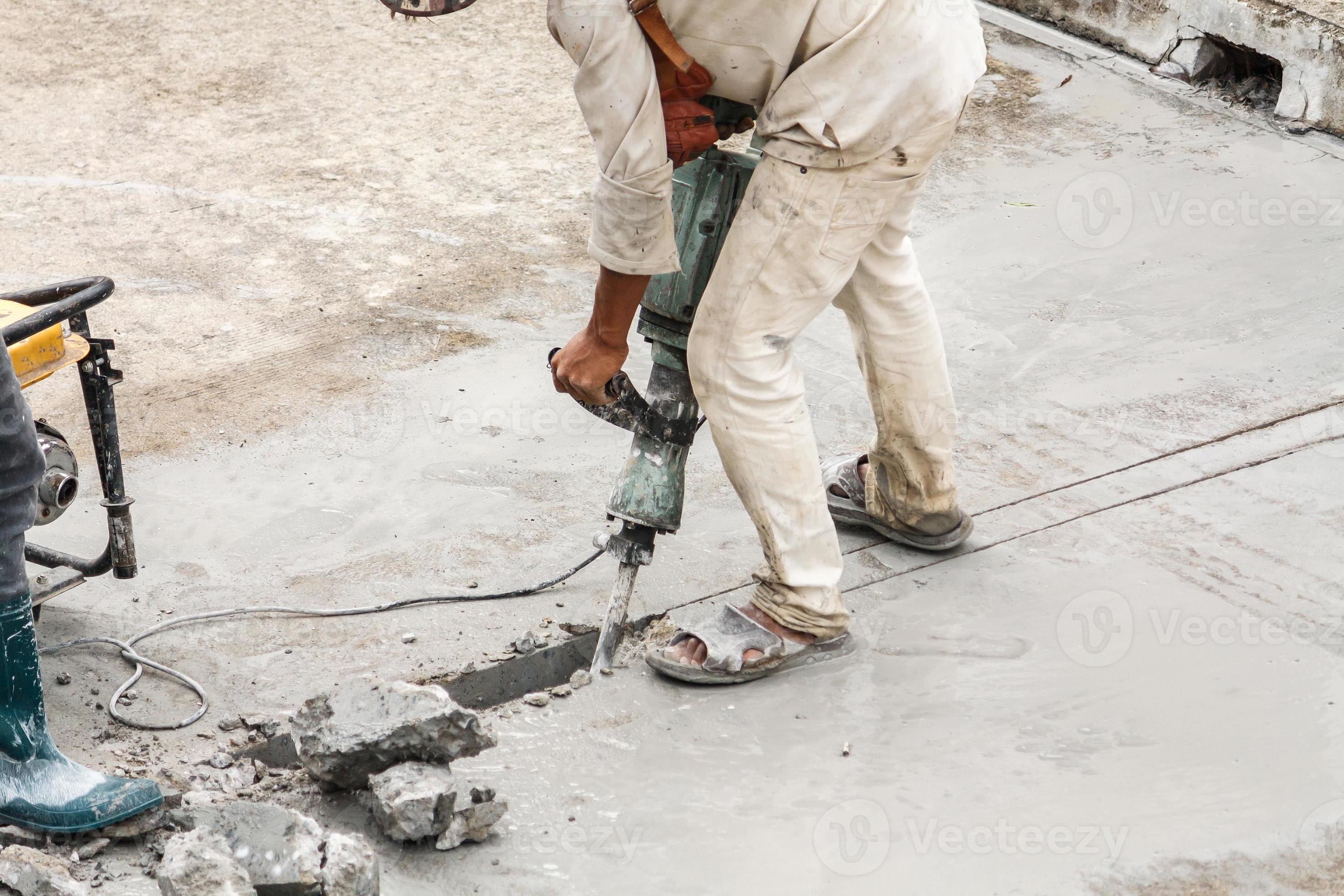 Construction worker using jackhammer drilling concrete surface 12834158