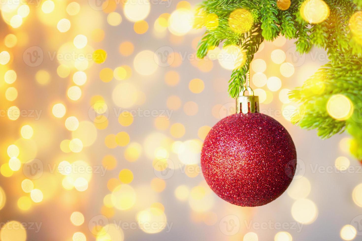 Christmas tree decorated with red ball on pine branches background photo