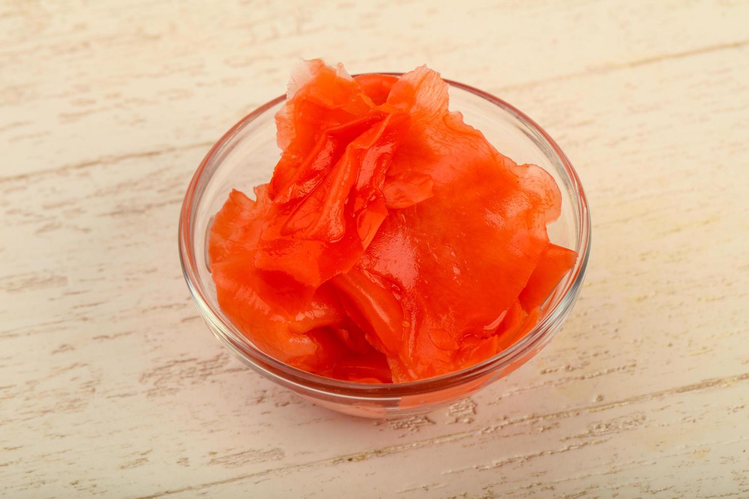 Picked ginger in a bowl on wooden background photo