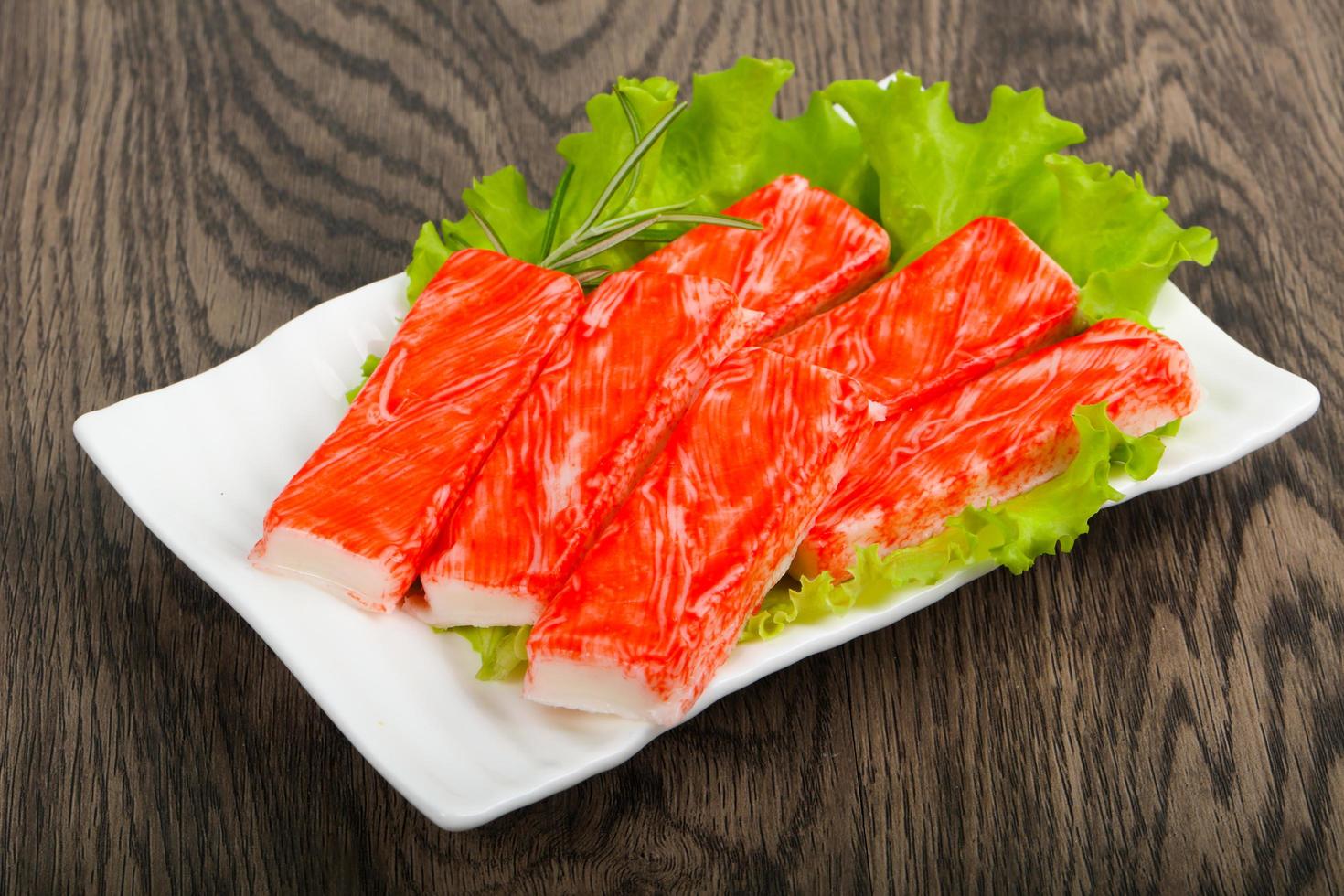Crab sticks on the plate and wooden background photo