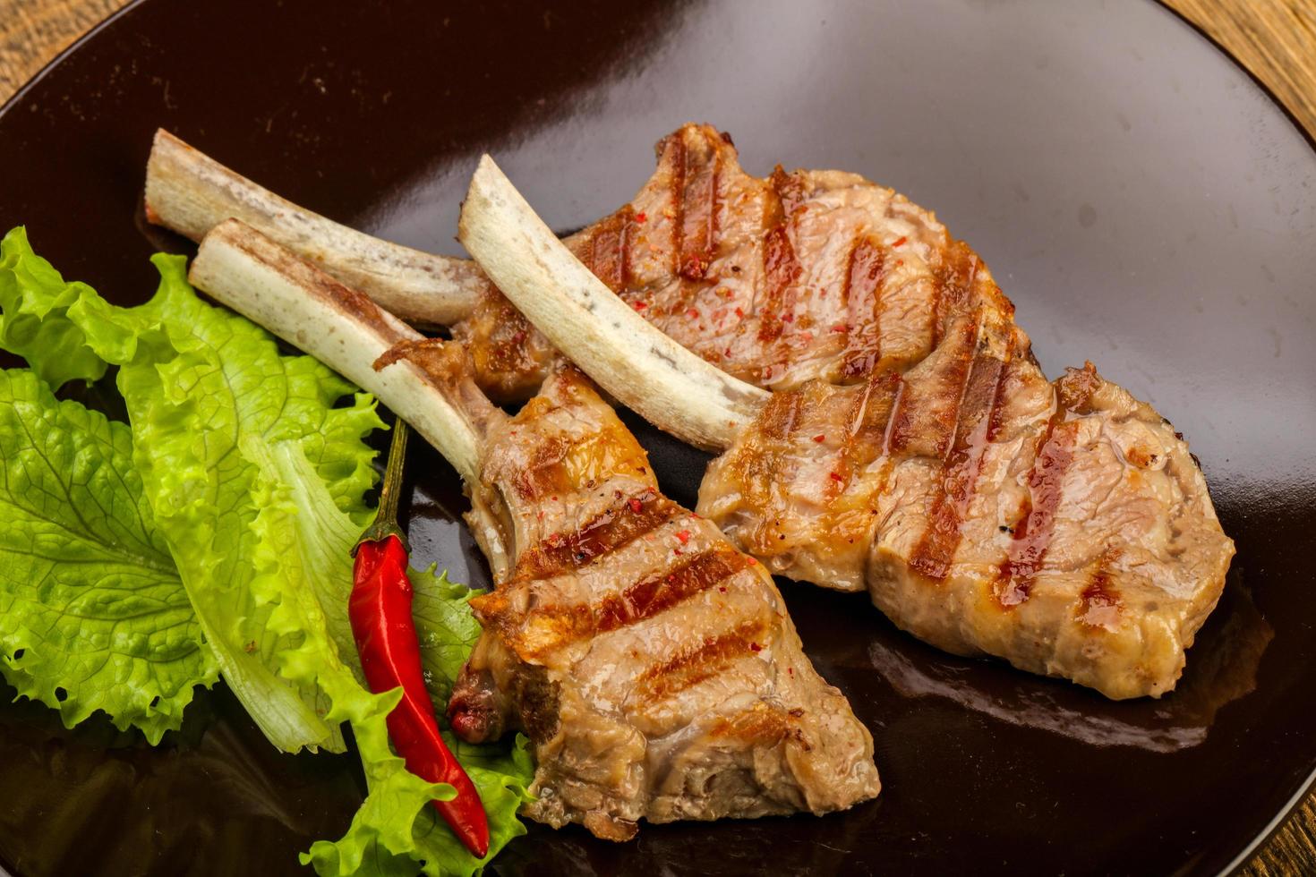 Grilled lamb on the plate and wooden background photo