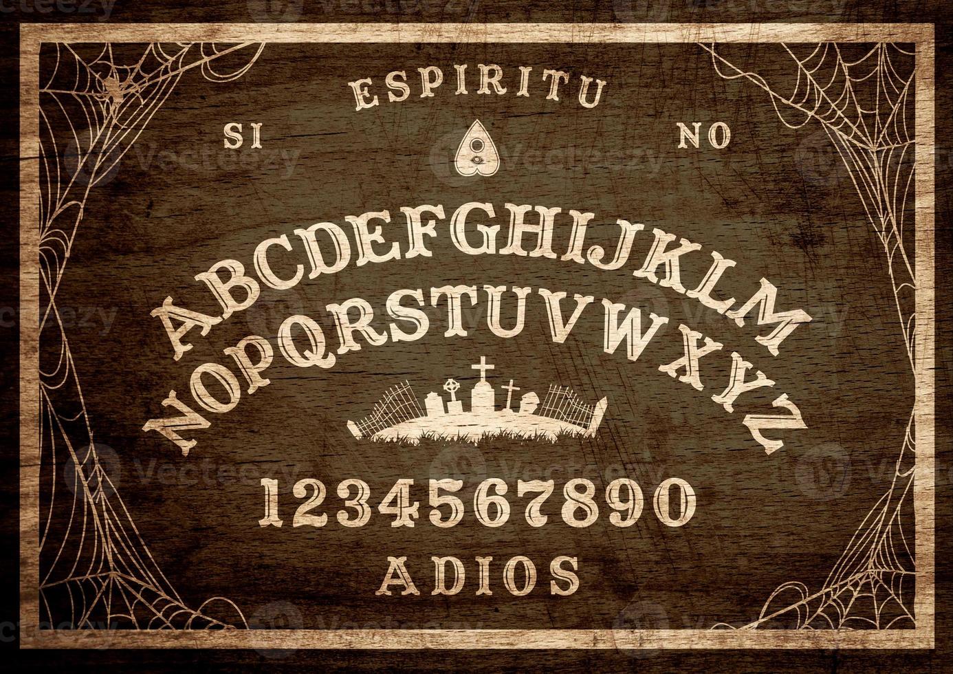 Halloween Ouija Board on wooden texture. Planchette play with calling souls and demons. Party poster. Graphic, caligraphy, typography, alphabet, letters, numbers and web. Cementery skyline. photo